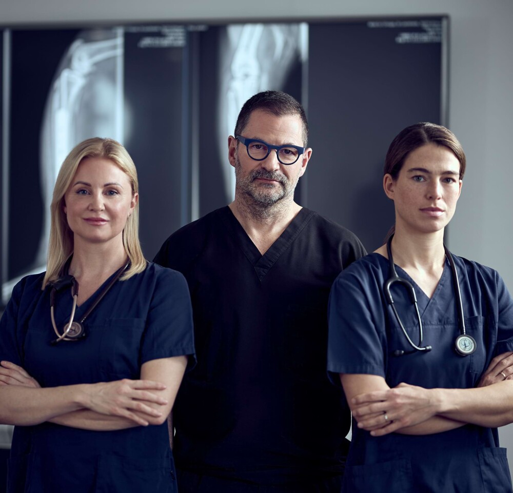 Dr. Lautersack und zwei Kolleginnen stehen mit verschr&auml;nkten Armen vor einer R&ouml;ntgenaufnahme.