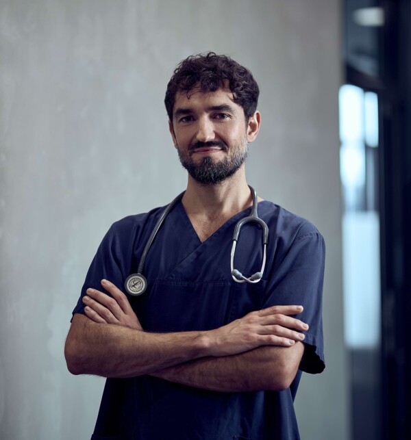 Ein Mitarbeiter steht selbstbewusst im Gang.