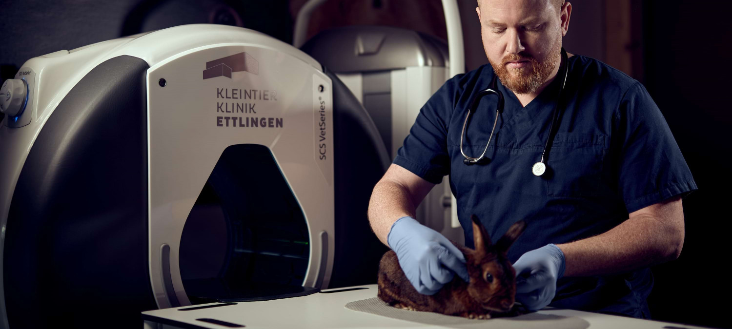 Spezialist Simon B&ouml;ser bei der Untersuchung eines Hasen vor einem speziellen CT f&uuml;r Kleintiere