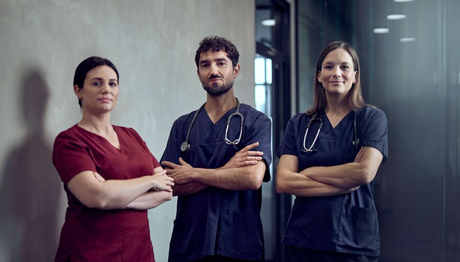 Eine &Auml;rztin und zwei Tierarzthelfer:innen stehen selbstbewusst im Gang.