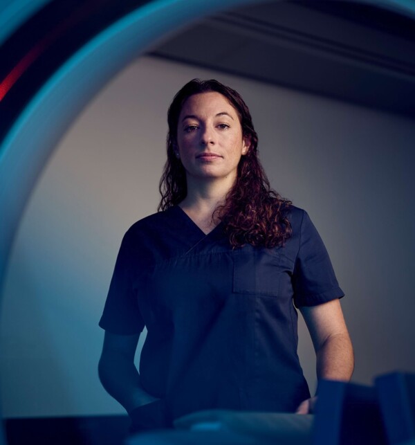 Eine Tierarzthelferin steht vor einem CT. Perspektive aus dem CT heraus.